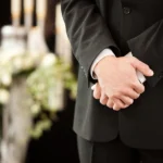 Close up of folded hands at furneral service