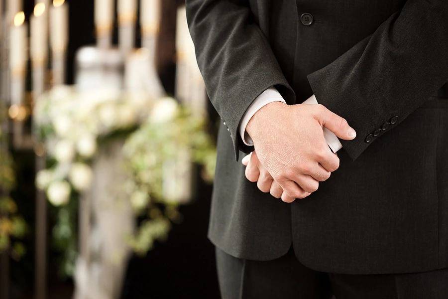 Close-up-of-folded-hands-at-furneral-service